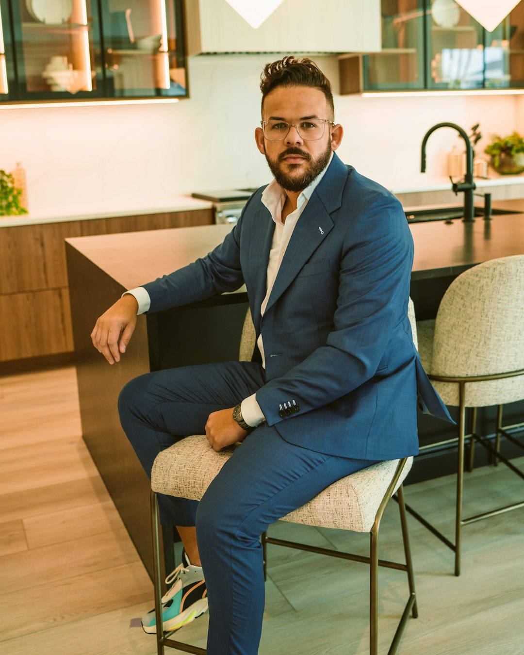 a-man-in-a-blue-suit-sitting-on-a-chair-mfyc1q-rv8k